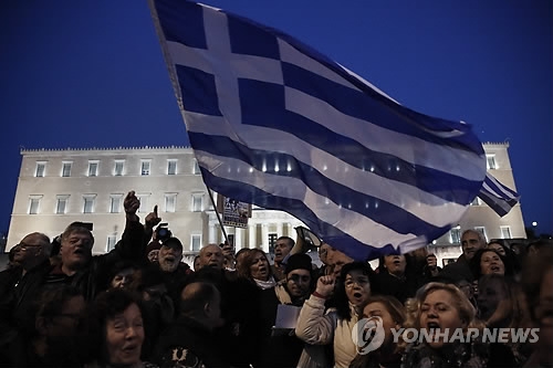 그리스 수도 아네테의 국회의사당 앞에서 알렉시스 치프라스 총리를 지지하는 시민들이 15일(현지시간) 대형 국기를 흔들며 긴축 반대 시위를 벌이고 있다. 이들은 