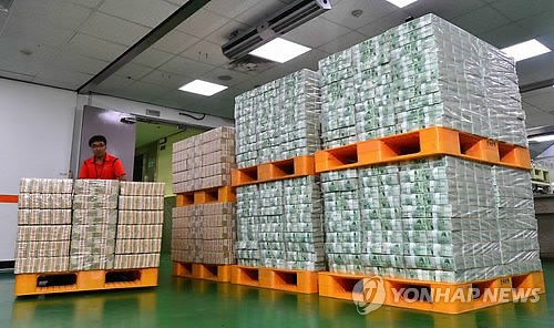 정부 재정으로 할 수 있는 사업에 한국은행의 발권력이 동원되는 사례가 줄을 잇고 있어 논란이 예상된다. 서울 소공동 한국은행 본점에서 자금운송 담당자가 화폐를 이송차량에 싣고 있다.