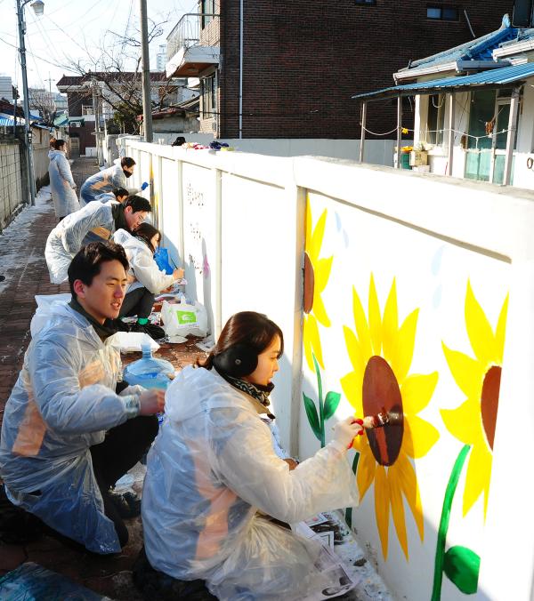 ▲신입행원들이 천안시에서 낙후된 골목길에 벽화 그리기, 야광페인트를 활용한 경보등을 설치하고 있는 모습. 지난 1일, 20개팀으로 구성된 230여명의 KB국민은행 신입행원들이 서울, 천안 지역일대에서 팀별로 다양한 봉사활동을 실시했다. (사진 : KB국민은행 제공)