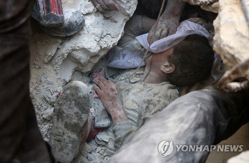 시리아 알레포 동부에서 정부군의 폭격에 파괴된 건물더미에서 구조되는 소년