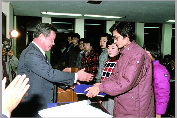 
▲고 최종현 회장이 1986년 해외 유학을 앞둔 한국고등교육재단 장학생들에게 장학증서를 전달하고 있다.  
