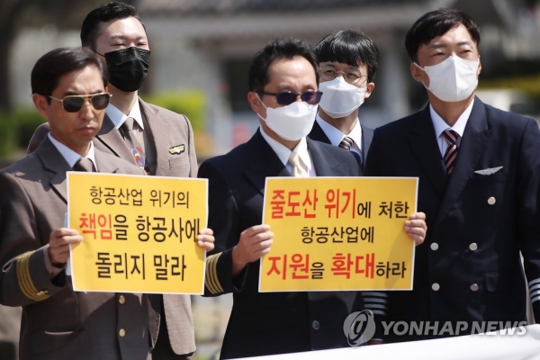 대한민국 조종사 노동조합 연맹과 전국연합노동조합연맹 소속 회원들이 14일 서울 청와대 분수대 앞에서 열린 '위기의 항공산업, 정부지원을 촉구하는 항공업계 노동조합 공동 기자회견'에서 손 팻말을 들고 있다.