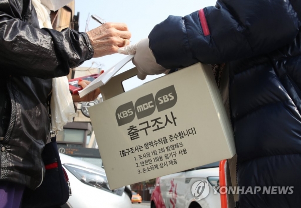 제21대 국회의원선거 투표일인 15일 서울 종로구 삼청동주민센터에 마련된 투표소 앞에서 한 유권자가 방송3사의 공동 출구조사에 응하고 있다. 