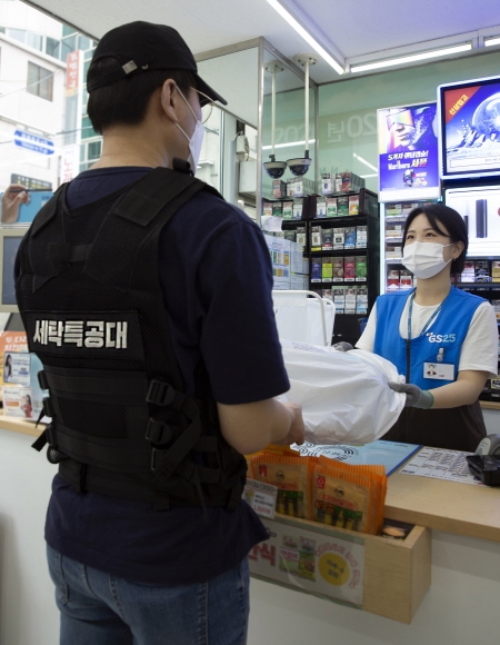 [첨부1] GS25 직원이 세탁특공대 직원에게 고객의 세탁물을 전달하고 있다 편의점