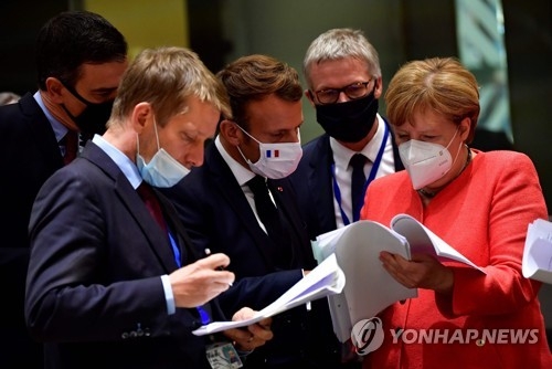 앙겔라 메르켈 독일 총리(맨 오른쪽)와 에마뉘엘 마크롱 프랑스 대통령(가운데) 등 EU 정상들이 20일(현지시간) 벨기에 브뤼셀에서 열린 EU 정상회의에서 자료를 함께 들여다보고 있다. [AFP=연합뉴스]