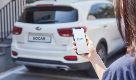 쏘카 모델이 해당 서비스 앱으로 카셰어링 차량을 호출하는 모습을 시연하고 있다. 