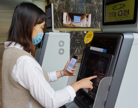 고객이 GS25 ATM에서 간편 결제 앱으로 현금 인출 서비스를 이용하고 있다.