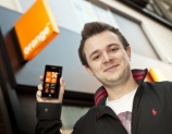 '옴니아7'의 첫 구매자가 '오렌지' 매장 앞에서 제품을 선보이고 있다.