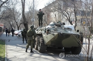 우크라이나 크림 수도 심페로폴 시내의 한 관청 건물 앞에서 15일(현지시간) 정체 불명의 군인들이 장갑차를 동원해 경계근무를 서고 있다.