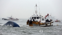 18일 오전 여객선 '세월호'가 침몰한 전남 진도군 조도면 병풍도 북쪽 3km 앞 사고 해상에서 빗속을 뚫고 구조대들이 공기 주입작업을 하고 있다.