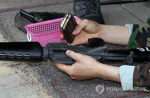 15일 육군 32사단 예하 대전 유성구 예비군훈련장에서 사격훈련 중인 한 예비군이 조교로 부터 실탄 3발이 들어있는 탄창을 전달받고 있다.