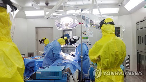 2일 중동호흡기증후군(메르스)으로 인해 부분 폐쇄한 서울 강동구 한림대학교 강동성심병원에서 신경외과 조병문 교수가 레벨 C 방호복을 입고 응급 뇌수술을 하고 있다.