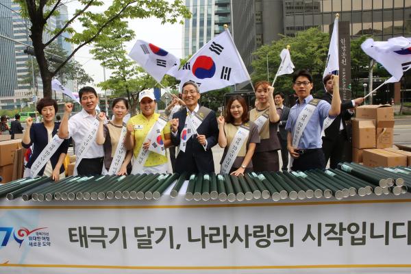 ▲KB국민은행 윤종규 은행장과 박인비 선수, 임직원들이 기념 촬영한 모습(왼쪽에서 다섯번째 KB국민은행 윤종규 은행장, 왼쪽에서 네번째 박인비 선수). KB국민은행은 11일 여의도에서 광복 70주년을 기념하여 국민들에게 무상으로 태극기를 나눠주는&lsquo;태극기 사랑&rsquo; 이벤트를 펼쳤다. (사진 : KB국민은행 제공)