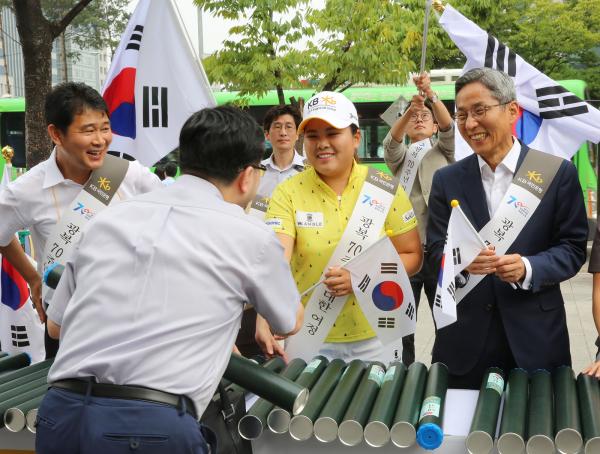 ▲KB국민은행 윤종규 은행장과 박인비 선수가 고객들에게 태극기를 나눠주는 모습. KB국민은행은 11일 여의도에서 광복 70주년을 기념하여 국민들에게 무상으로 태극기를 나눠주는&lsquo;태극기 사랑&rsquo; 이벤트를 펼쳤다. (사진 : KB국민은행 제공)