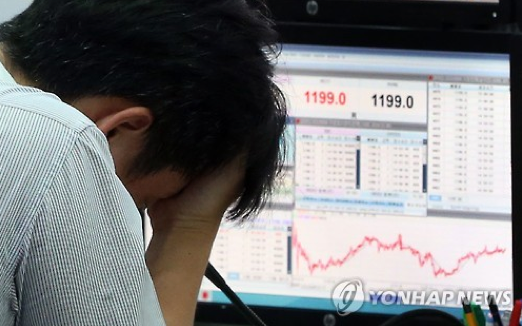 남북 간 군사긴장과 중국발 쇼크로 금융시장이 매우 불안한 모습을 보인 24일 오후 서울 중구 외환은행 본점 딜링룸에서 한 딜러가 괴로운 모습을 하고 있다. 이날 코스피는 장중 1,800선까지 위협받았고, 원/달러 환율은 종가 기준으로 약 5년 만에 최고치를 갈아치웠다.