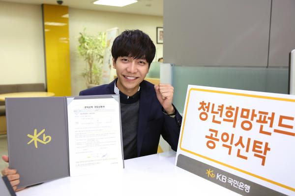 ▲탤런트 이승기가 KB국민은행 청년희망펀드 공익신탁 상품 가입증서를 들고  화이팅하는 모습. 지난 12일, 탤런트 이승기는 KB국민은행 압구정중앙지점에서 청년 일자리창출을 지원하는&lsquo;청년희망펀드 공익신탁&rsquo;상품을 가입했다.