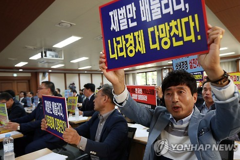 소상공인연합회 등 대기업 피해소상공인 공동대책위원회 관계자들이 19일 오전 서울 의여도 중소기업중앙회 회의실에서 열린 롯데 면세점 특허권 연장 반대 기자회견에서 손팻말을 들고 구호를 외치고 있다. 