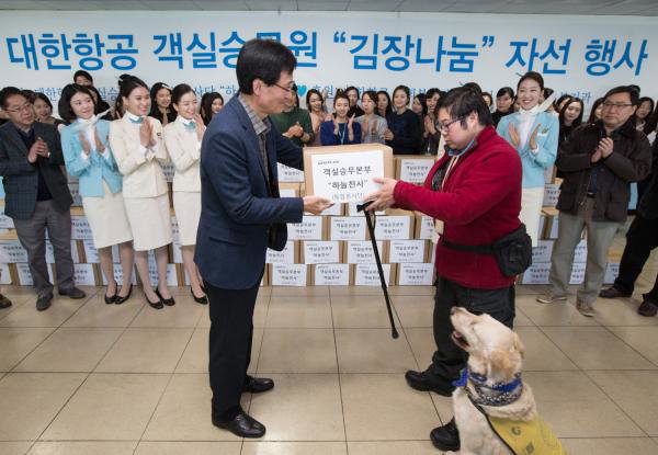 ▲조병택 객실승무본부장(왼쪽)이 행사 관계자에게 김장 김치를 전달하고 있는 모습. 대한항공은 지난 12월 5일 서울 공항동 소재 본사에서 &lsquo;하늘사랑 김장나눔&rsquo;행사를 가졌다. 이날 행사에는 대한항공 객실승무원들로 구성된 봉사단체인 &lsquo;하늘천사&rsquo; 자원봉사자와 임직원 가족, 강서구청 소속 봉사자 등 250명이 참여해 약 1,500포기의 김장 김치를 만들어 강서지역 내 어려운 이웃들에게 전달했다.(사진 : 대한항공 제공)