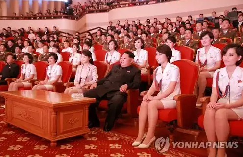  김정은 북한 국방위원회 제1위원장과 부인 리설주가 북한판 '걸그룹' 모란봉악단과 함께 앉아 새로 생긴 '청봉악단'의 공연을 관람하는 모습