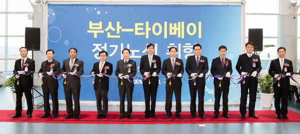 ▲부산~타이베이 신규노선 취항식에 참석한 이진호 대한항공 한국지역본부장과 홍기호 부산광역시 교통국장 등 관계자들이 취항 기념 테이프 커팅을 하고 있는 사진. 사진은 이진호 대한항공 한국지역본부장(왼쪽에서 여섯번째)과 홍기호 부산광역시 교통국장(왼쪽에서 다섯번째).  대한항공은 1월 25일 오전 7시 30분 부산 김해공항 10번 출국장에서 이진호 대한항공 한국지역본부장과 홍기호 부산광역시 교통국장 등 관계자들이 참석한 가운데 부산~타이베이 신규 취항 행사를 가졌다.