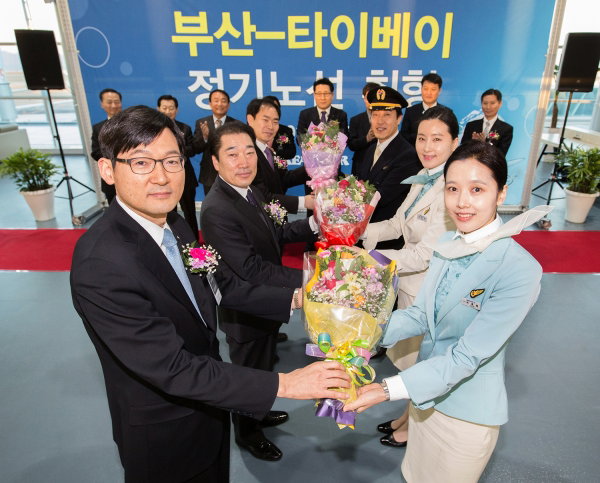 ▲부산~타이베이 신규노선 취항식에 참석한 이진호 대한항공 한국지역본부장과 홍기호 부산광역시 교통국장 등 관계자들이 꽃다발을 받고 있는 모습. 사진은 이진호 대한항공 한국지역본부장(앞줄 왼쪽에서 첫번째)과 홍기호 부산광역시 교통국장(앞줄 왼쪽에서 두번째).  대한항공은 1월 25일 오전 7시 30분 부산 김해공항 10번 출국장에서 이진호 대한항공 한국지역본부  장과 홍기호 부산광역시 교통국장 등 관계자들이 참석한 가운데 부산~타이베이 신규 취항 행사를 가  졌다. (사진 : 대한항공 제공) 