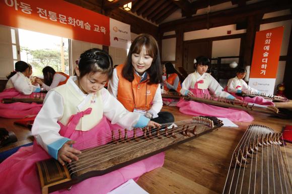▲4월 21일, 서울 남산국악당 체험실에서 전통문화예술교육사업인 &lsquo;한화예술더하기&rsquo; 사회공헌 활동에 참석한 한화그룹 임직원 봉사자들과 아동들이 가야금 교육에 참여하고 있다. (사진 : 한화그룹 제공)