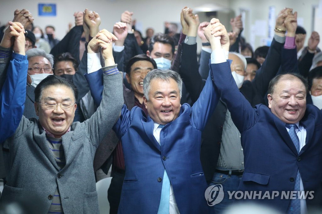 15일 총선 개표 결과 당선이 유력한 제주시갑 선거구 더불어민주당 송재호 후보(가운데)가 지지자들과 손을 잡고 만세를 부르고 있다. 2020.4.15