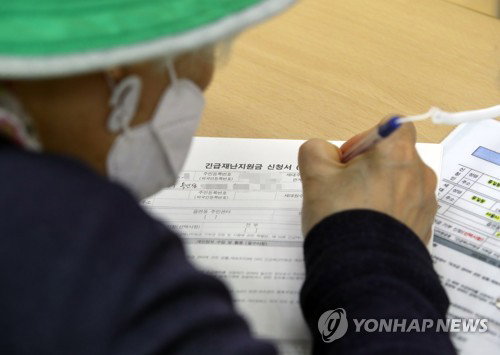 긴급재난지원금 오프라인 신청 접수 첫날인 18일 서울 종로구 청운효자동 주민센터에서 한 주민이 신청서를 작성하고 있다. 이날부터 지역사랑상품권·선불카드 신청을 전국 읍·면·동 주민센터에서 받기 시작하고, 그간 온라인으로 접수해온 신용·체크카드 충전 방식도 각 카드사 연계 은행 창구를 통한 방문 신청이 가능하다. 2020.5.18 긴급재난지원금 오프라인 신청 접수 첫날인 18일 서울 종로구 청운효자동 주민센터에서 한 주민이 신청서를 작성하고 있다. 이날부터 지역사랑상품권·선불카드 신청을 전국 읍·면·동 주민센터에서 받기 시작하고, 그간 온라인으로 접수해온 신용·체크카드 충전 방식도 각 카드사 연계 은행 창구를 통한 방문 신청이 가능하다. 2020.5.18