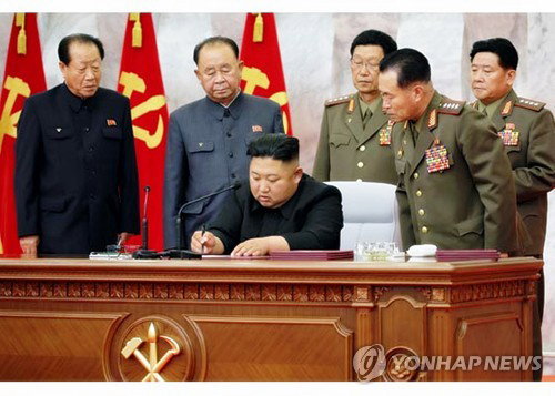 북한은 김정은 국무위원장이 주재한 가운데 당 중앙군사위원회 제7기 제4차 확대회의를 열었다고 북한매체들이 24일 보도했다. 이번 회의에서는 당 중앙군사위 인사도 단행됐다. 승진 인사 대상인 최부일, 리병철, 김수길, 박정천, 김정관(왼쪽부터)이 문서에 서명하는 김정은 위원장을 보고 있다. 2020.5.24 