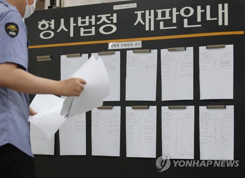 22일 오전 서초구 서울중앙지법에서 법원 관계자가 재판 일정을 게시판에 붙이고 있다. 2020.5.22
