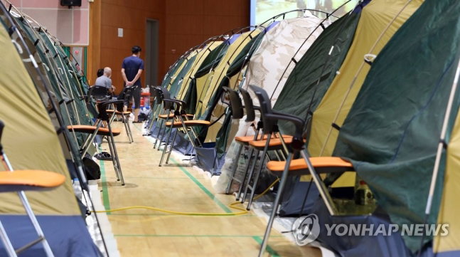 '코로나 와중에 수해까지' (구례=연합뉴스) 정회성 기자 = 지난 10일 전남 구례군 구례여자중학교 강당에 마련된 이재민 대피소에 주택 침수 피해를 본 주민이 생활하는 텐트가 줄지어 있다.