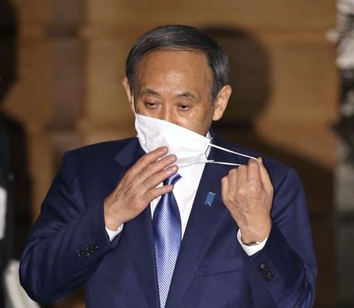 스가 요시히데 총리가 지난 16일 관저에서 기자들의 취재에 응하며 마스크를 벗고 있