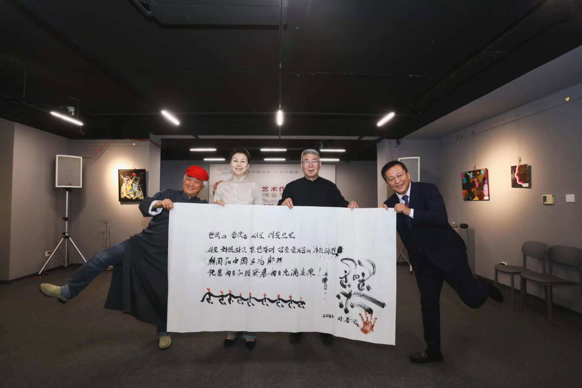 [한&middot;중 예술작품교류전 개막식에서 양국 예술가들이 함께 그린 서화 작품을 들고 기념 촬영 (선양시정부 외사판공실 제공)]