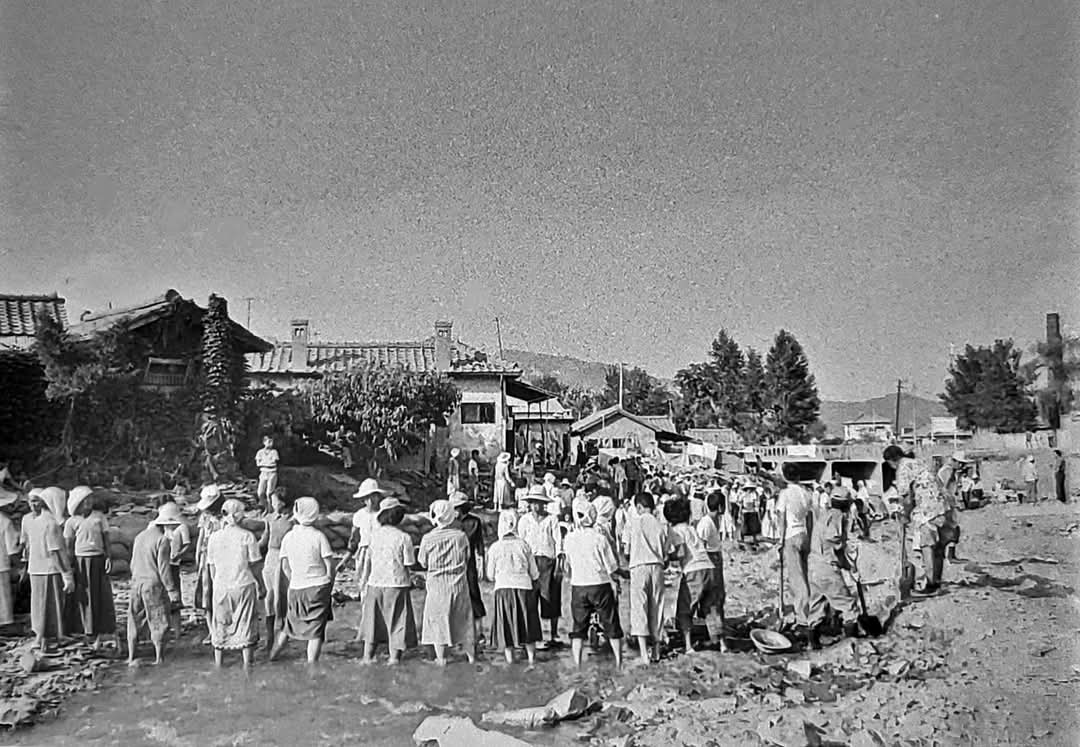 [1977년 7월 안양에 내린 폭우로 폐허가 된 수암천에 주민들이 나와 수해복구 작업하는 모습]