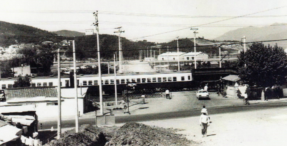 [1971년 시흥군 안양읍 안양 5리에서 안양 7리를 지나 비산리로 이어지던 철도 건널목 사진이다. 1번 국도와 경부선 철도가 지나가는 건널목으로 우마차나 자전거 사람들이 안전하게 통행할 수 있도록 차단기를 설치 열차가 들어오면 땡땡땡 소리가 울린다 해 땡땡이 길로 불렸다. 지금은 사람과 차량이 안전하게 다닐 수 있는 비산 고가차도가 건설되어 안양을 동서로 연결하는 중요한 도로가 된 곳이다]
